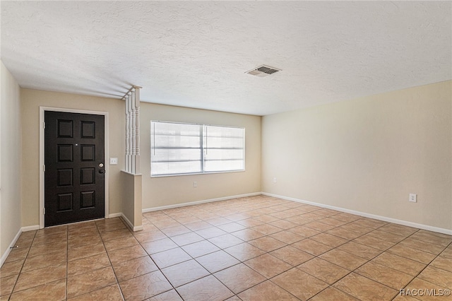 entryway featuring light tile patterned floors and a textured ceiling