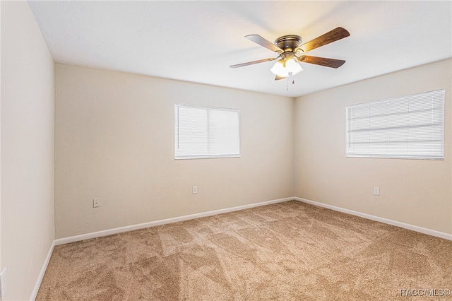 spare room with carpet, a wealth of natural light, and ceiling fan