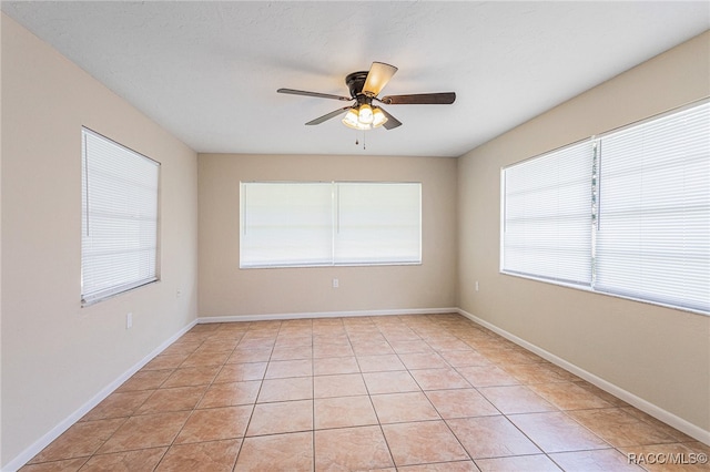 tiled spare room featuring ceiling fan