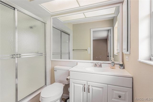 bathroom with vanity, toilet, and a shower with shower door