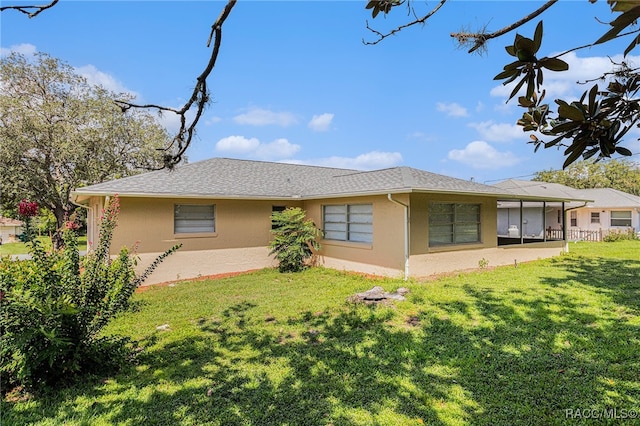 back of property featuring a sunroom and a yard