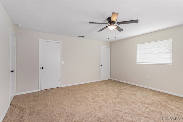 carpeted empty room featuring ceiling fan