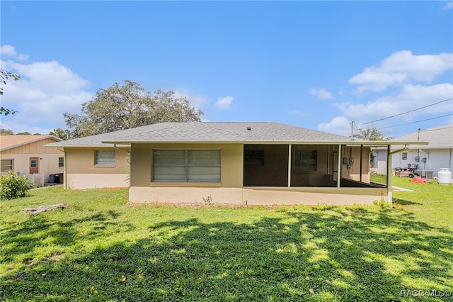 back of property with a sunroom and a yard