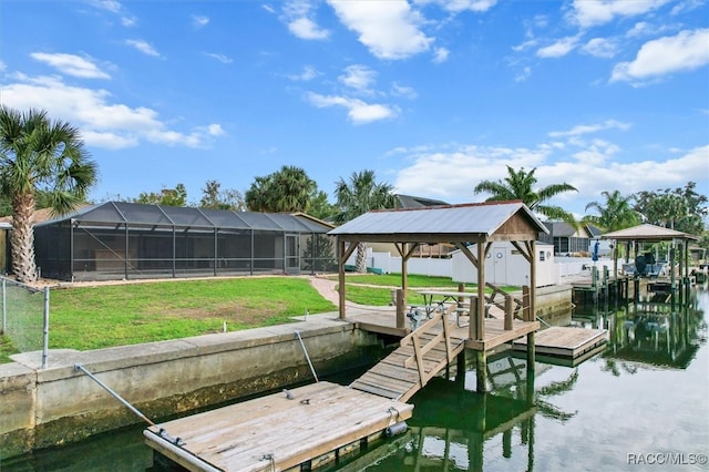 dock area with a lanai, a gazebo, a water view, and a yard