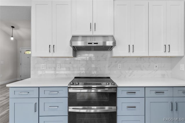 kitchen featuring wall chimney exhaust hood, tasteful backsplash, stainless steel range with electric cooktop, white cabinets, and hardwood / wood-style flooring