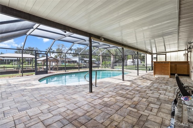 view of swimming pool featuring glass enclosure and a patio