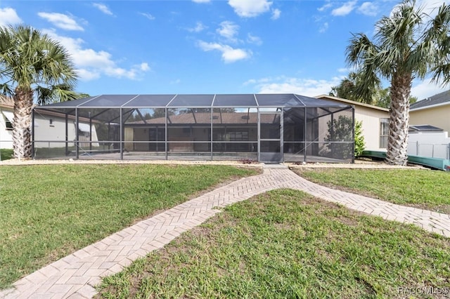 back of property with a lanai and a lawn