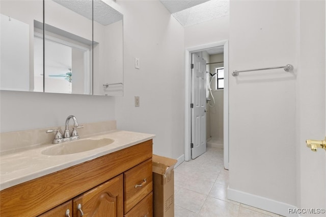 bathroom featuring tile patterned floors, vanity, and a textured ceiling