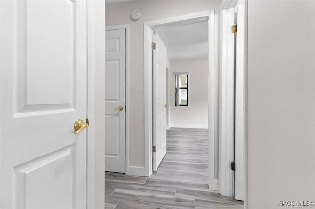 hallway with light hardwood / wood-style floors