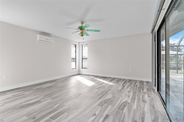 empty room featuring a wall unit AC, ceiling fan, and light hardwood / wood-style flooring