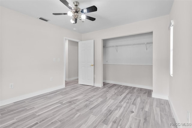 unfurnished bedroom with ceiling fan, light wood-type flooring, and a closet