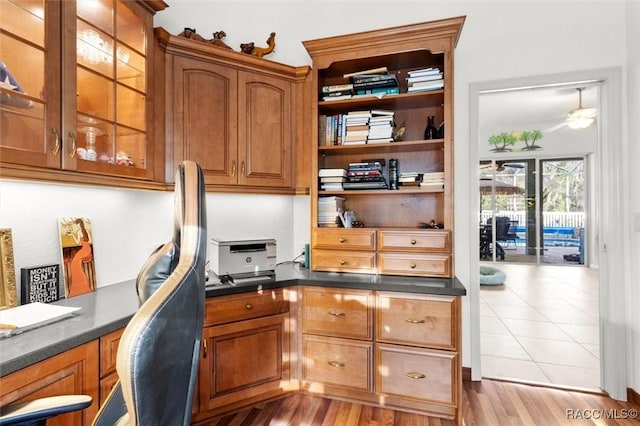 home office with wood finished floors and built in study area