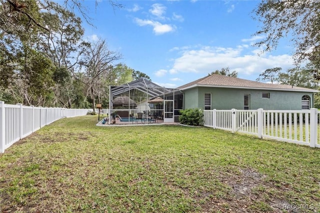 back of house featuring glass enclosure, a fenced backyard, and a yard