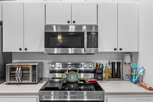 kitchen featuring appliances with stainless steel finishes, light countertops, and white cabinetry