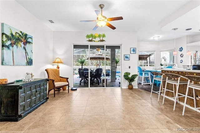 interior space with ceiling fan, visible vents, baseboards, and tile patterned floors