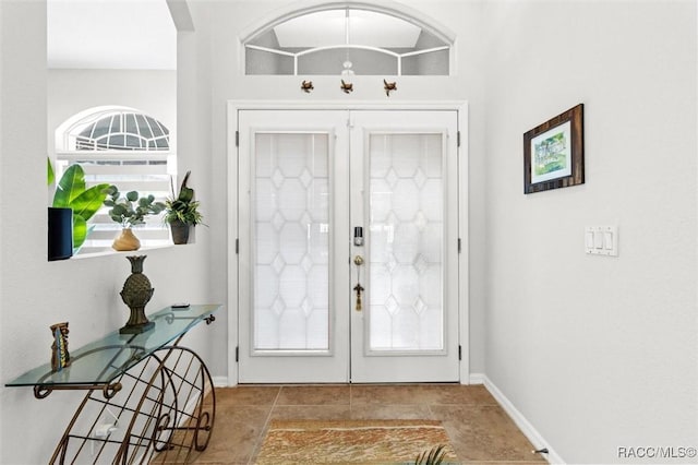 foyer entrance featuring french doors and baseboards