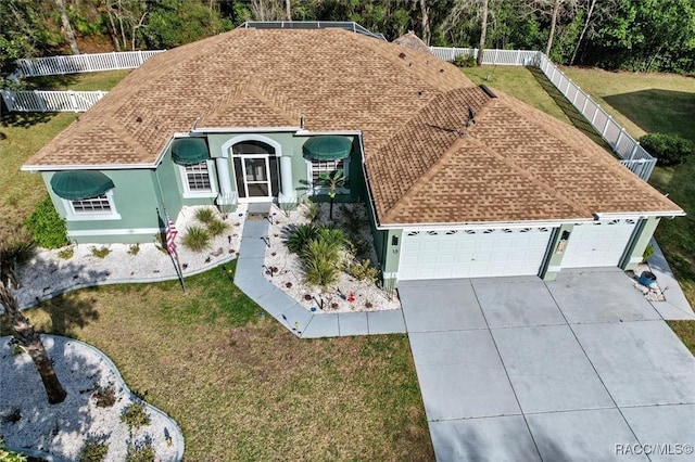 view of front of property featuring a shingled roof, fence, and concrete driveway