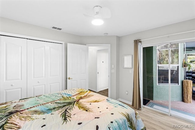 bedroom featuring baseboards, visible vents, wood finished floors, access to exterior, and a closet