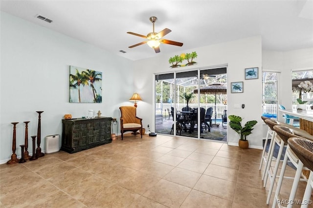 sitting room with baseboards, tile patterned flooring, visible vents, and a ceiling fan