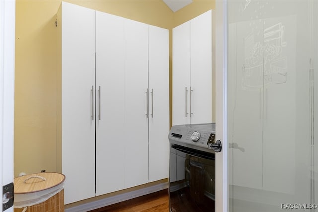 interior space with washer / dryer, vaulted ceiling, and hardwood / wood-style floors