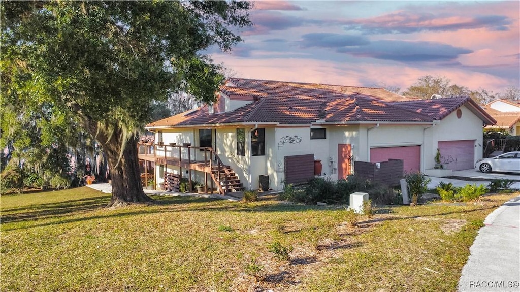 view of front of home with a yard and a garage