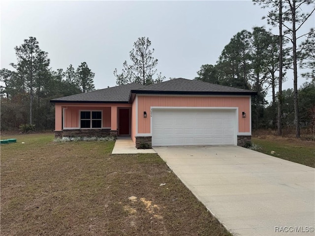 view of front of property with a shingled roof, concrete driveway, an attached garage, board and batten siding, and a front lawn