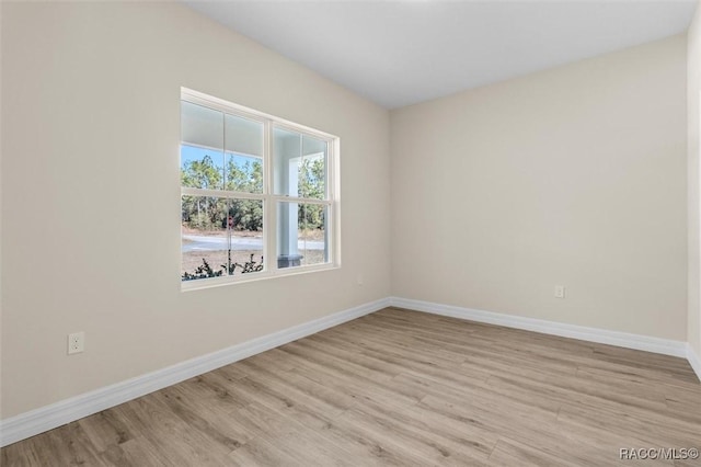 spare room with light wood-style flooring and baseboards