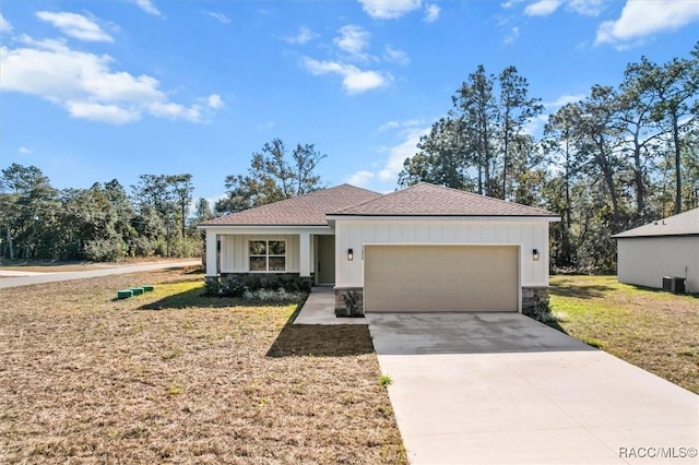 view of front of home with cooling unit, a garage, driveway, a front lawn, and board and batten siding