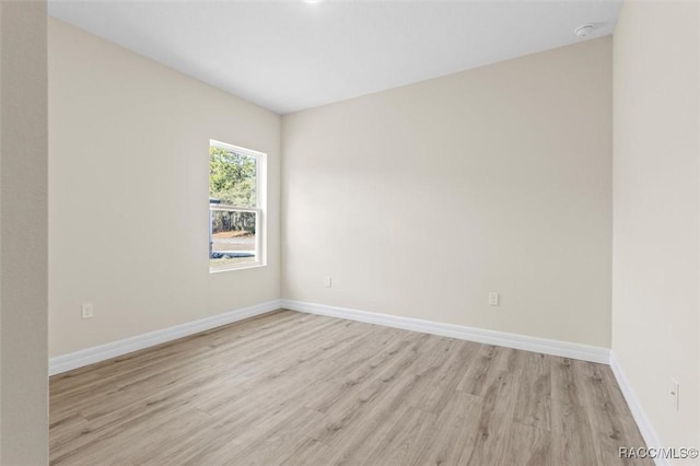 empty room with light wood-style flooring and baseboards