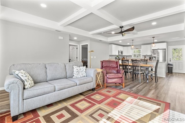 living room with hardwood / wood-style flooring, ceiling fan, beam ceiling, and a wealth of natural light