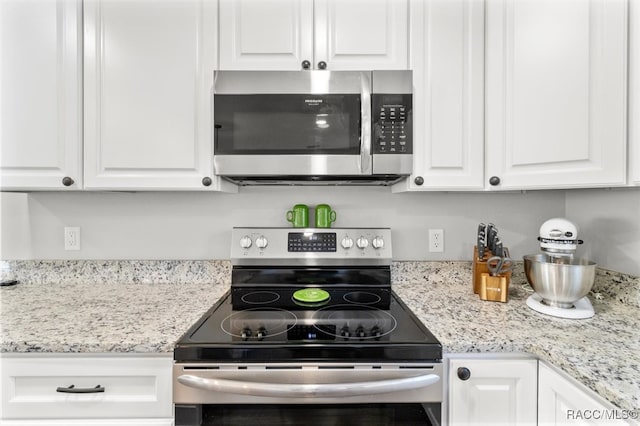 kitchen featuring white cabinets, light stone countertops, and appliances with stainless steel finishes