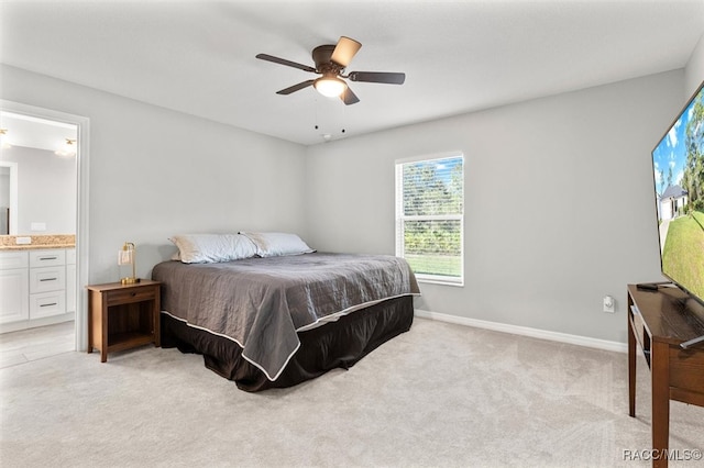 carpeted bedroom with ensuite bathroom and ceiling fan