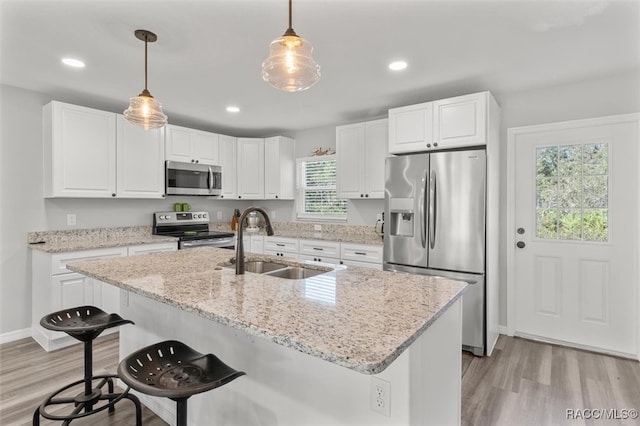 kitchen with white cabinets, appliances with stainless steel finishes, a healthy amount of sunlight, and sink