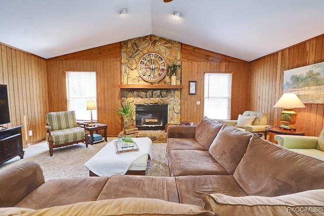 carpeted living room featuring wooden walls, lofted ceiling, and a stone fireplace