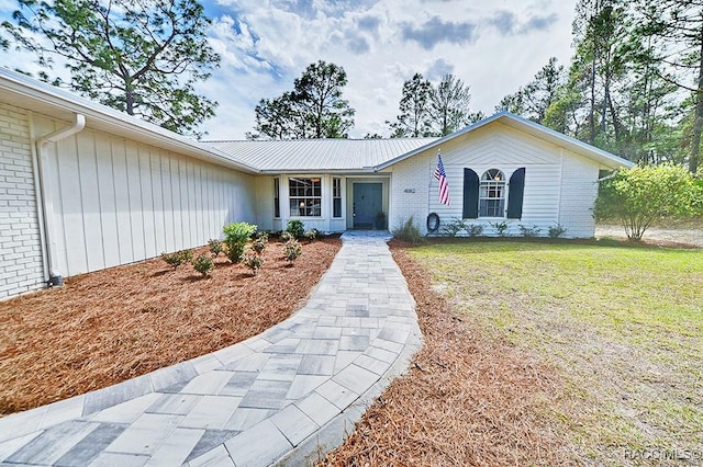 ranch-style house featuring brick siding and a front yard