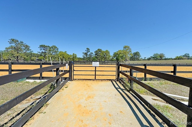 view of gate with a rural view and an enclosed area