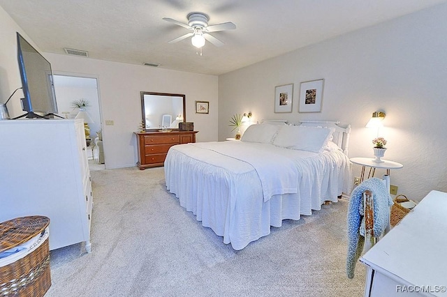 bedroom featuring visible vents, a ceiling fan, and light colored carpet