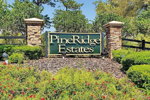 community / neighborhood sign featuring fence