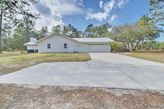 ranch-style home with a garage, concrete driveway, and a front yard