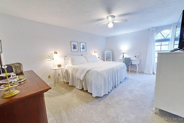 bedroom featuring a textured ceiling, ceiling fan, baseboards, and light colored carpet