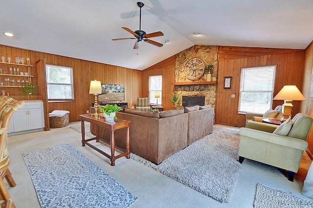 living area with vaulted ceiling, a fireplace, and wooden walls