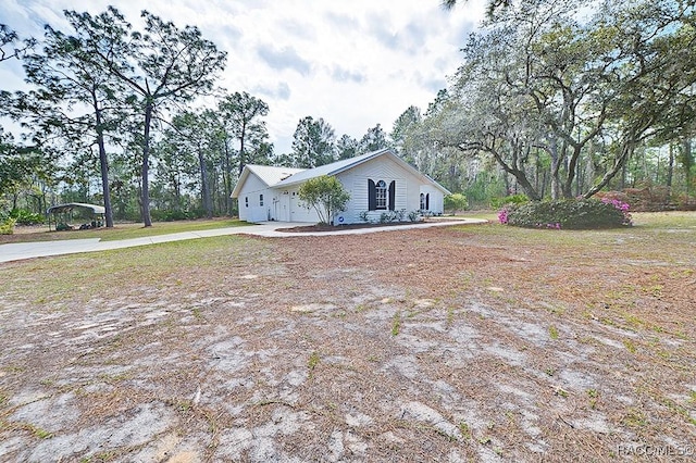 view of property exterior featuring concrete driveway and an attached garage