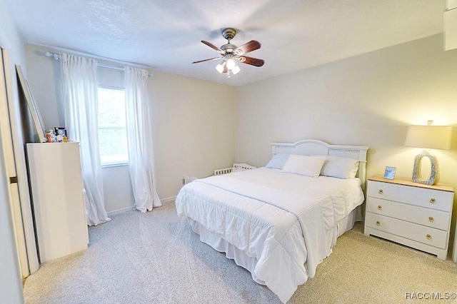 bedroom with light carpet and a ceiling fan