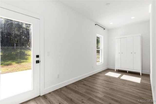 unfurnished bedroom with recessed lighting, wood finished floors, and baseboards