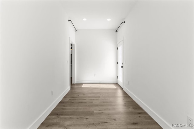 hall with recessed lighting, wood finished floors, and baseboards