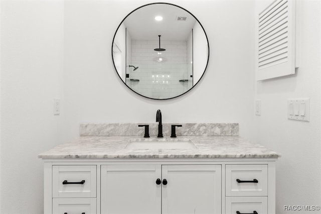 bathroom featuring vanity and tiled shower