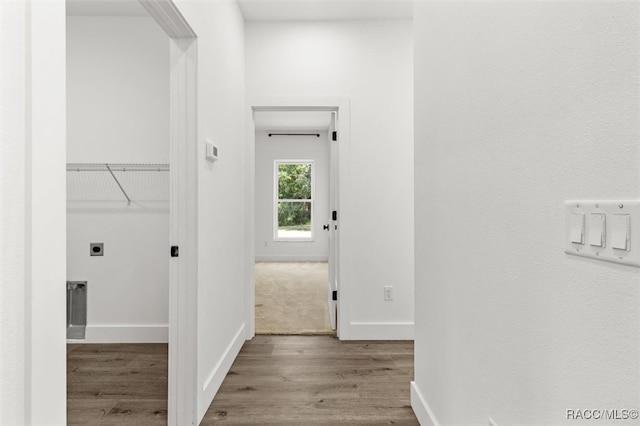 corridor with baseboards and wood finished floors