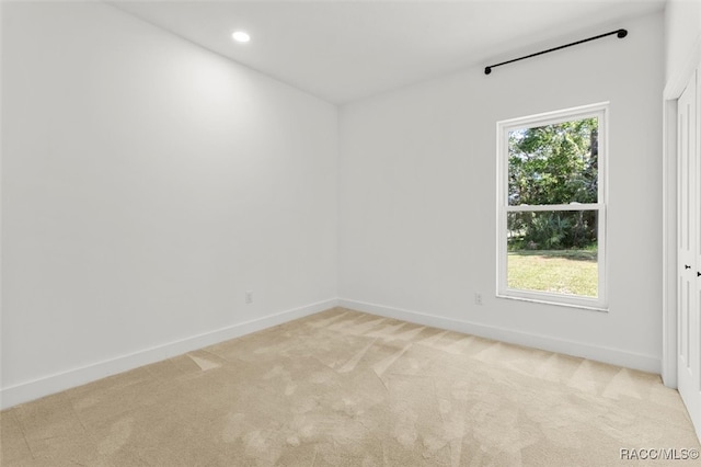 spare room with light colored carpet and plenty of natural light