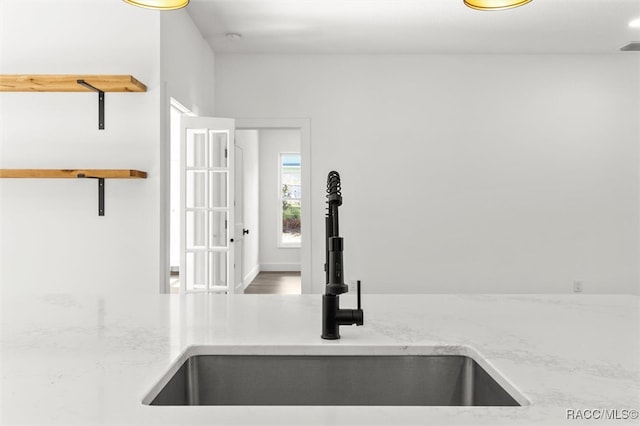 details featuring a sink and light stone countertops