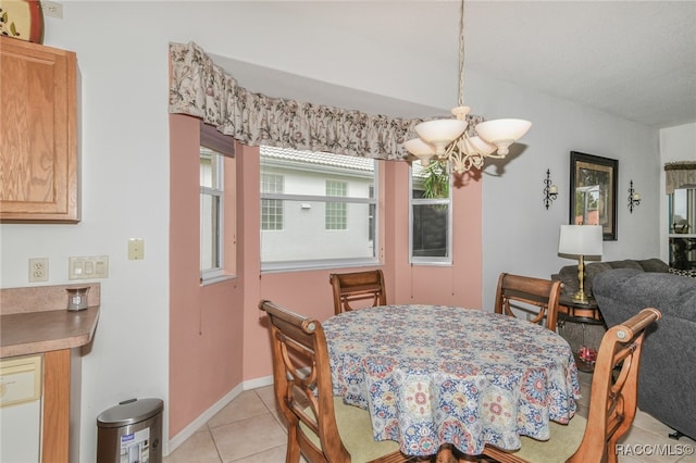 tiled dining area with an inviting chandelier and a healthy amount of sunlight